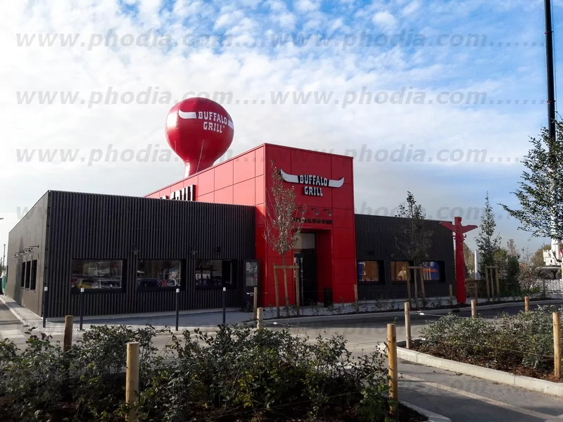montgolfiere buffalo grill rouge de 6m de haut posée sur un toit